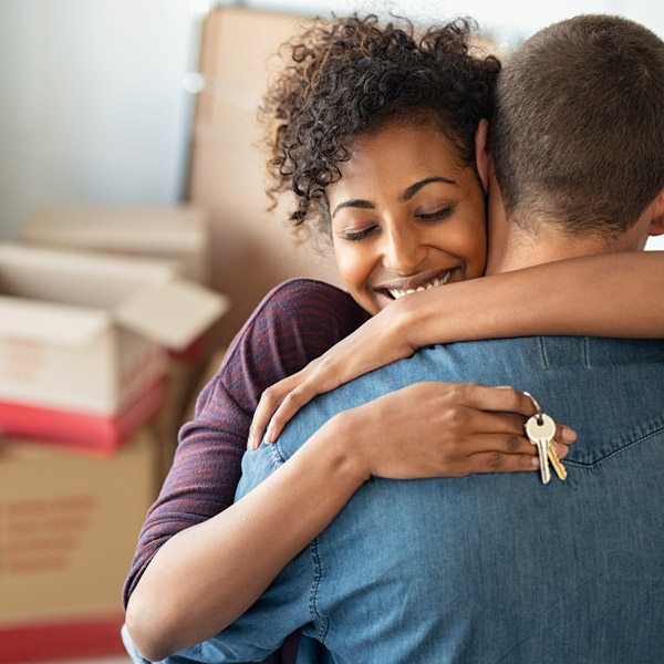 couple hugging after purchasing new home